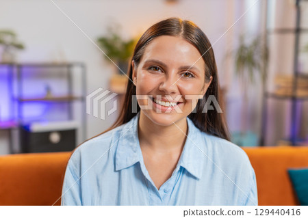 Portrait of happy calm Caucasian woman at home couch smiling friendly, looking at camera resting 129440416