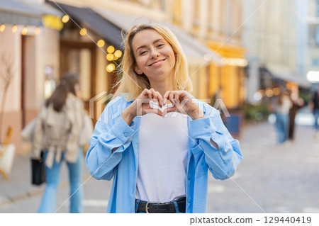 Woman makes symbol of love showing heart sign to camera charity gratitude donation positive feelings Woman makes symbol of love showing heart sign to camera charity gratitude donation positive feelings 129440419