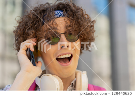 Happy young man tourist having remote conversation communicate speaking by smartphone with friends 129440620