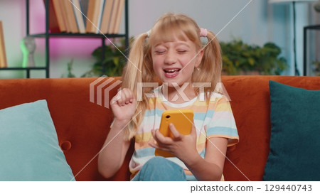 Child kid girl use smartphone playing, great big surprise, good news, celebrate online game win 129440743