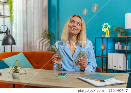 Woman counting money cash use smartphone calculator application calculate income earnings home bills 129440747