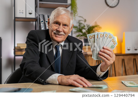 Rich Caucasian senior businessman counting money cash calculate earnings income profit at home Rich Caucasian senior businessman counting money cash calculate earnings income profit at home 129440794