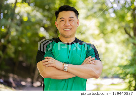 Portrait of happy Japanese sporty man athlete healthy lifestyle posing looking at camera in park Portrait of happy Japanese sporty man athlete healthy lifestyle posing looking at camera in park 129440887