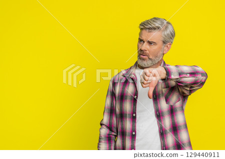 Upset mature man guy showing thumbs down gesture disapproval dissatisfied dislike negative feedback Upset mature man guy showing thumbs down gesture disapproval dissatisfied dislike negative feedback 129440911