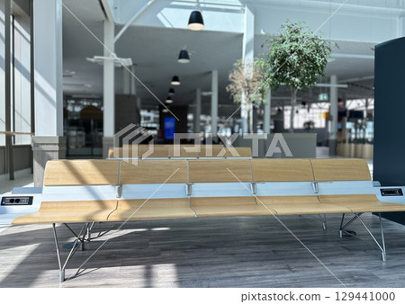 A modern and minimalist shot of an empty waiting area, likely an airport terminal or a large public building. 129441000
