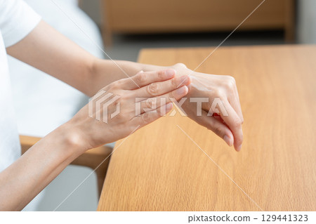 Woman applying cream to her hand 129441323