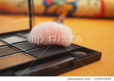 Makeup tools and cosmetics laying on a table 129441694