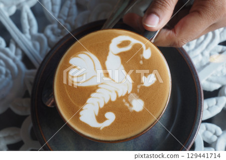 Coffee art creating a beautiful design on latte 129441714