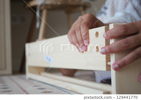 Building a wooden shelf with hand tools indoors 129441770