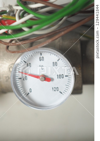 Temperature gauge indicating heat levels on a pipe 129441844