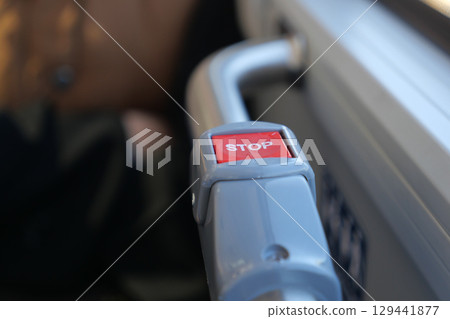 Bus stop button on public transport in urban setting 129441877