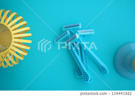 Bright blue razors arranged on a turquoise background 129441882