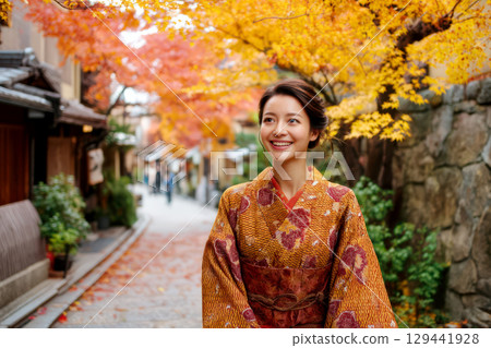一位身著和服的女子身處古鎮，周圍是色彩繽紛的秋葉 129441928