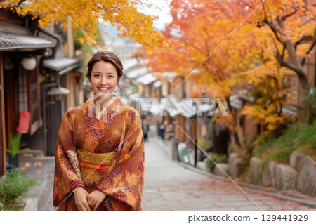 一位身著和服的女子身處古鎮，周圍是色彩繽紛的秋葉 129441929