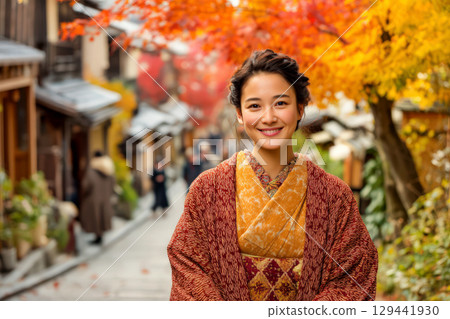 一位身著和服的女子身處古鎮，周圍是色彩繽紛的秋葉 129441930
