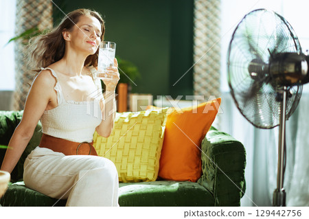 Woman Finds Refreshment on Sofa with Iced Water 129442756