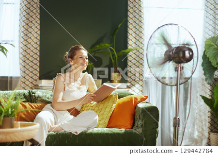Joyful Woman Laughing while Cooling Down with a Book Joyful Woman Laughing while Cooling Down with a Book 129442784