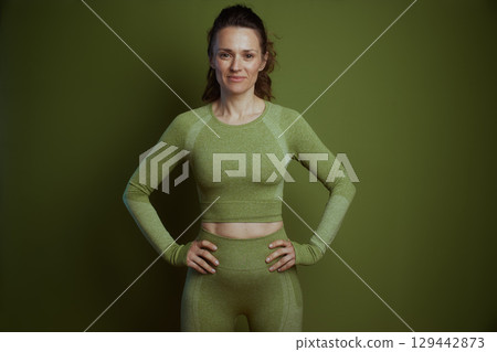 Confident woman in olive green sportswear 129442873