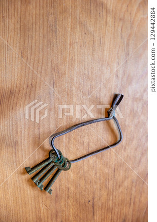 Antique key bunch and wood grain background_vertical 129442884
