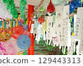 Many wind chimes, colorful teru teru bozu dolls, and Japanese umbrellas swaying in the wind are displayed at the Wind Chime Festival at Kasuga Shrine in Wakayama Prefecture. 129443313