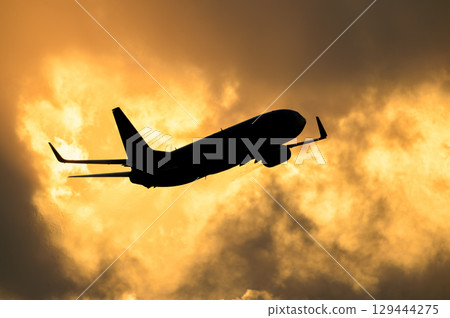 飛機在日落背景下起飛和降落 129444275