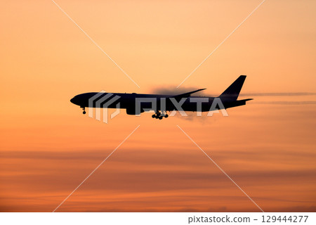 飛機在日落背景下起飛和降落 129444277