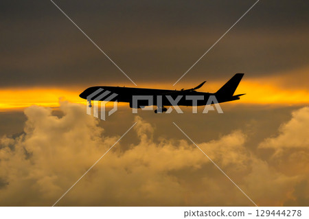 飛機在日落背景下起飛和降落 129444278