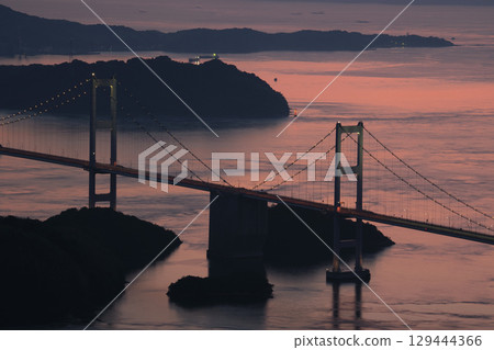 愛媛郡今治市：黃昏時分，連結本州和四國的來島海峽大橋橫跨粉紅色的海面。 129444366