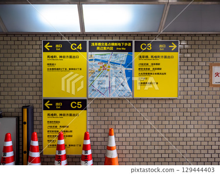 Area guide map and exit directions posted in the underground walkway 129444403