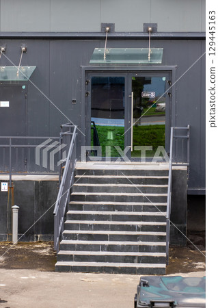 A striking black building that features stairs leading up to it A striking black building that features stairs leading up to it 129445163