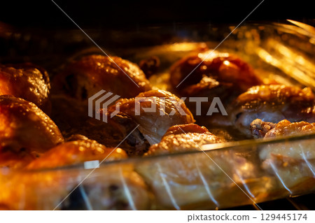 A large casserole dish of delicious chicken is cooking perfectly 129445174