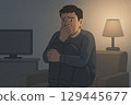 Young man watching a horror movie in a dark room 129445677