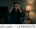 Man watching a horror movie in a dark room 129445678