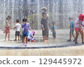 Children enjoying splashing around in the fountain in midsummer 129445972