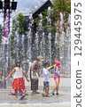 Children enjoying splashing around in the fountain in midsummer 129445975
