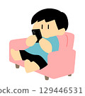 一位男士在沙發上休息，同時看著他的智慧型手機 129446531