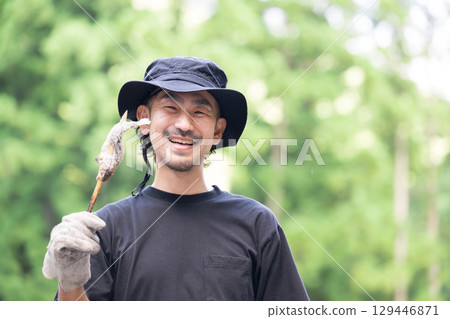 Outdoor man eating river fish at camp 129446871