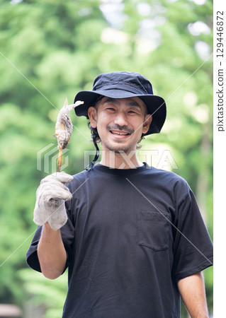 Outdoor man eating river fish at camp 129446872