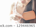 A woman stroking her hair 129446965