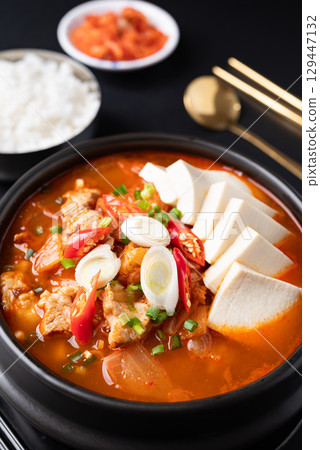 Korean food (Kimchi Jjigae), Kimchi soup with tofu, pork, scallion and chili in Korean stone bowl  129447132