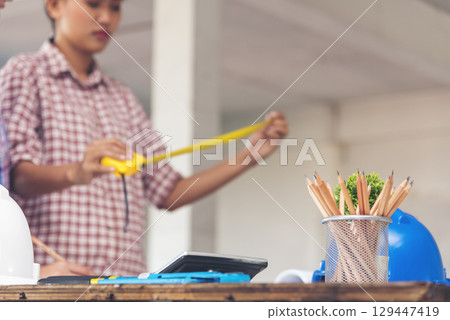 Woman engineer hands working at office desk architecture. Women engineer hands drawing architect blueprint write paperwork table office supply. Engineering calculate measurement construction hardhat 129447419