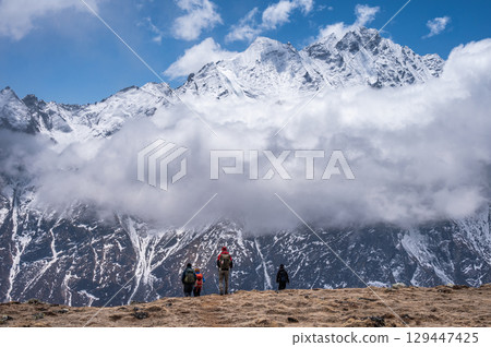 Tourist while trekking on Tsergo Ri (4,990m) the high point on the Langtang valley trek of Nepal. Tourist while trekking on Tsergo Ri (4,990m) the high point on the Langtang valley trek of Nepal. 129447425