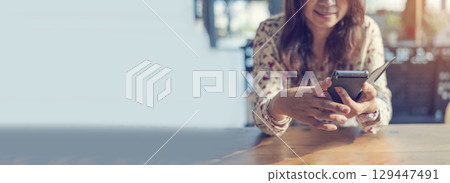 Banner Women sitting on sofa using smartphone, credit card to shopping online with smiling face shopaholics. Panorama Happy asian women lay down use smartphone. Woman online shopping with copy space 129447491