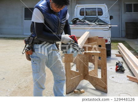 A carpenter is cutting wood using a circular saw angle ruler and a circular saw 129448126