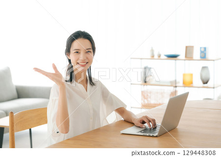 A woman using a personal computer at home 129448308