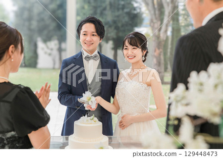 在婚禮上切蛋糕的新郎新娘和賓客(結婚蛋糕/切蛋糕) 在婚禮上切蛋糕的新郎新娘和賓客(結婚蛋糕/切蛋糕) 129448473