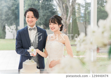 在婚禮上切蛋糕的新郎新娘和賓客(結婚蛋糕/切蛋糕) 在婚禮上切蛋糕的新郎新娘和賓客(結婚蛋糕/切蛋糕) 129448474