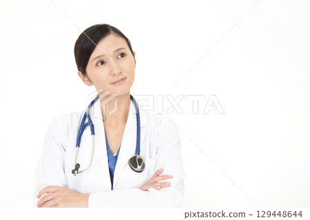 Female doctor looking up Female doctor looking up 129448644