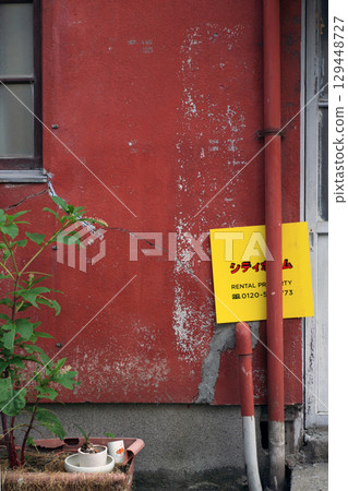 一棟舊木製公寓大樓的紅牆 一棟舊木製公寓大樓的紅牆 129448727