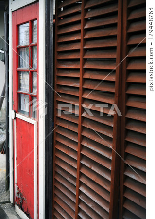 Red door and wooden louvers Red door and wooden louvers 129448763